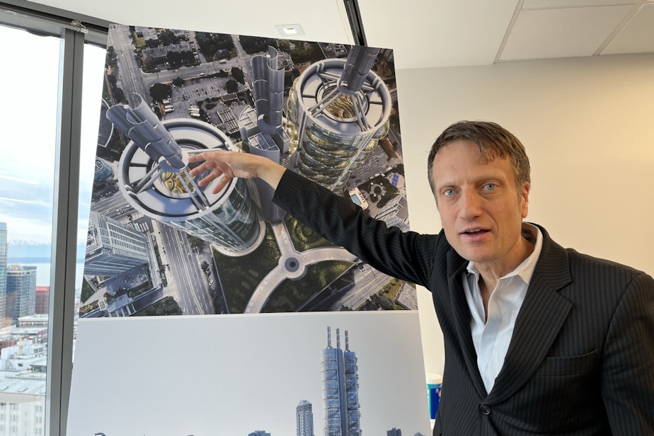 caption: Matthias Olt points at a rendering of the UN-tower produced at his previous firm, B+H Advance Strategy.