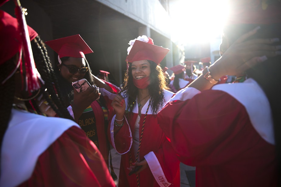 caption: Cleveland Stem High School senior Parris Sanjose laughs with classmates before the in-person commencement ceremony on Tuesday, June 15, 2021, at Memorial Stadium in Seattle.