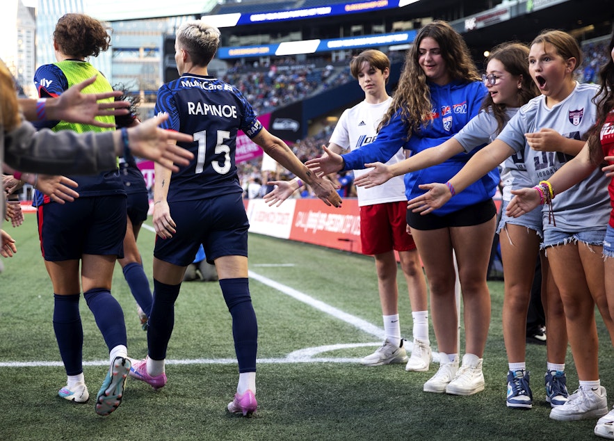 caption: Young fans react after high-fiving OL Reign forward Megan Rapinoe as she walks onto the field to play her final NWSL regular-season home game against the Washington Spirit on Friday, October 6, 2023, at Lumen Field in Seattle. KUOW Photo/Megan Farmer