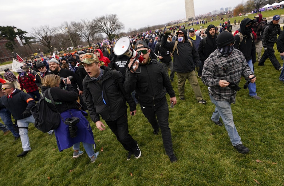 caption: Wednesday, Jan. 6, 2021. Ethan Nordean, with backward baseball hat and bullhorn, leads members of the far-right group Proud Boys in marching before the riot at the U.S. Capitol. Nordean, 30, of Auburn, Washington, has described himself as the sergeant-at-arms of the Seattle chapter of the Proud Boys.