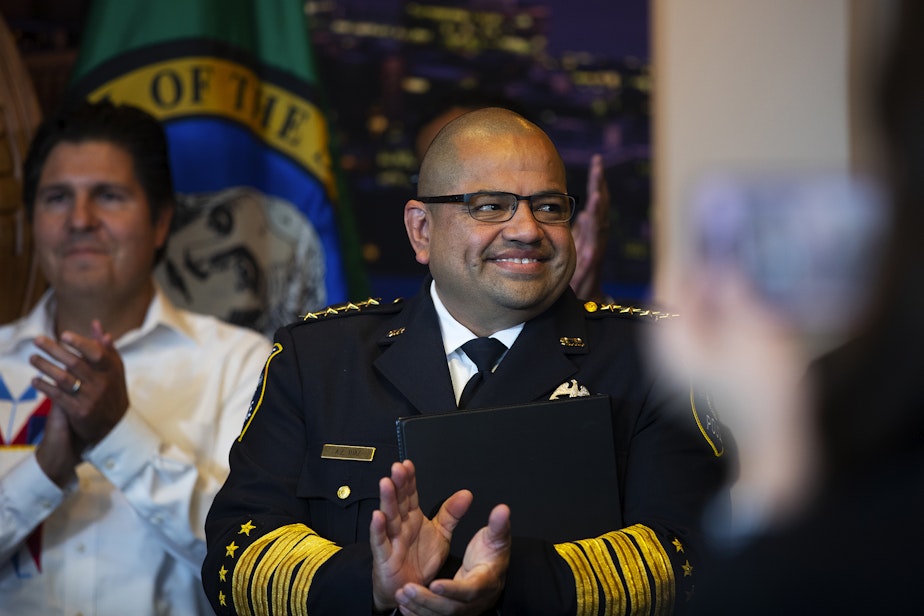 caption: Adrian Diaz smiles and claps during a press conference where he was announced by Seattle mayor Bruce Harrell as the new permanent Seattle Police Chief on Tuesday, September 20, 2022, at Seattle City Hall.