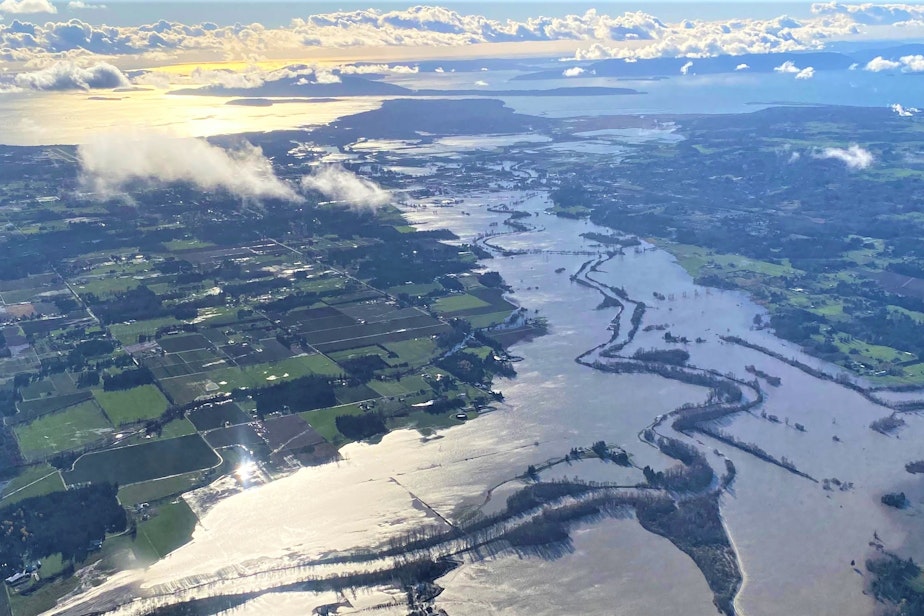 caption: The flooded Nooksack River in Whatcom County on Nov. 16, 2021 with the San Juan Islands in the background