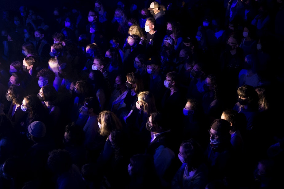 caption: A crowd of masked people listen as Madeline The Person performs on Friday, November 12, 2021, at Neumos along East Pike Street in Seattle.
