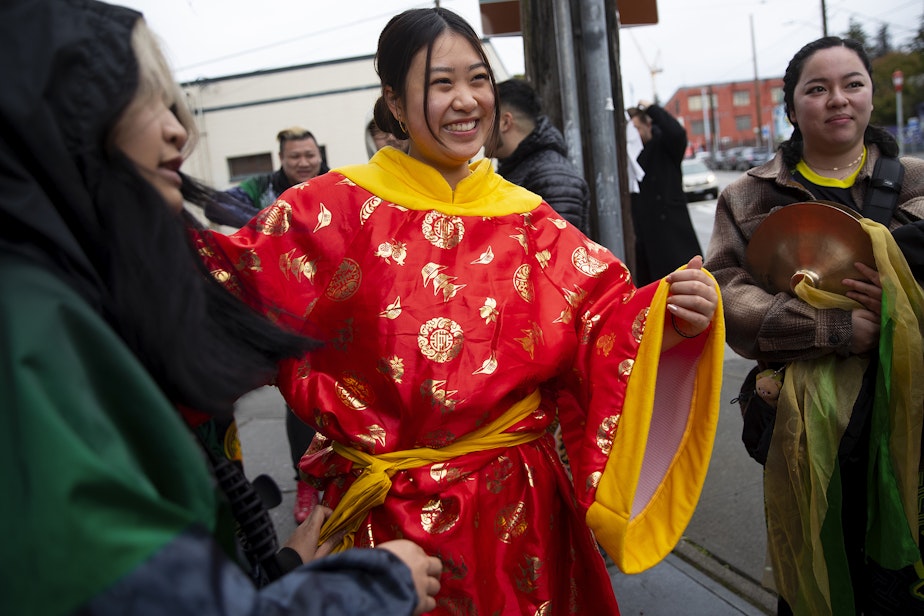 caption: Tiffany Hoang smiles while getting ready to perform with the Mak Fai Lion and Dragon dancers during the Lunar New Year celebration on Saturday, Feb. 4, 2023, in Seattle’s Chinatown-International District.