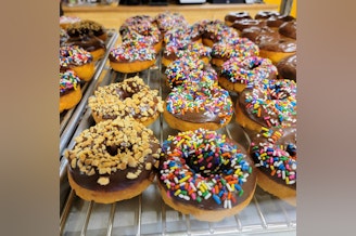 caption: Peanut and sprinkle-covered donuts are as fancy as they get at Kirkland's Countryside Donuts.
