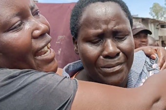 caption: Isabella Mogeni, 54, from the neighborhood of Mukuru kwa Reuben, looks on as bulldozers destroy homes in the slum area on May 3.