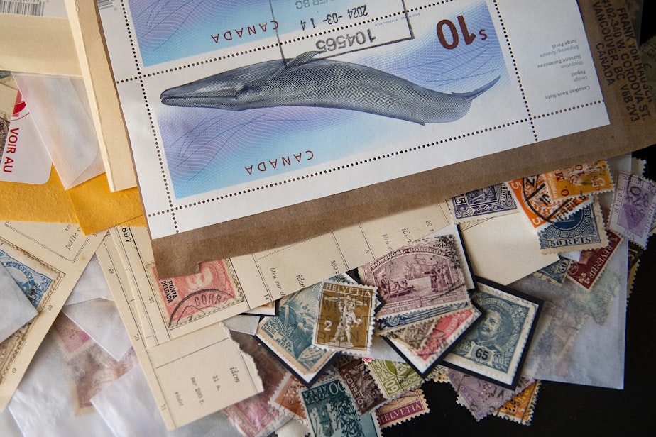 caption: A variety of stamps from all over the world are piled together at the Museum of Artistamps on Tuesday, March 26, 2024, in Seattle.