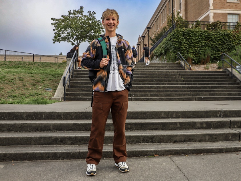 caption: Finn Flanigan, a freshman at Roosevelt High School in northeast Seattle said he is getting into clothes. On his first day of school, September 4, 2024, Finn wore pants he thrifted in Portland, Oregon, and a worn T-shirt of an Alaskan bear that he found at a pop-up vintage store in Ravenna.
