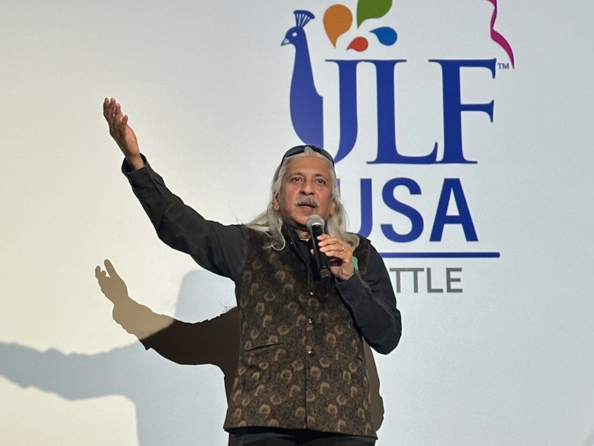 caption: Sanjoy K. Roy, the managing director of Teamwork Arts, welcomes an audience to the first Jaipur Literature Festival in Seattle at the Seattle Asian Art Museum on Sept. 20, 2024.
