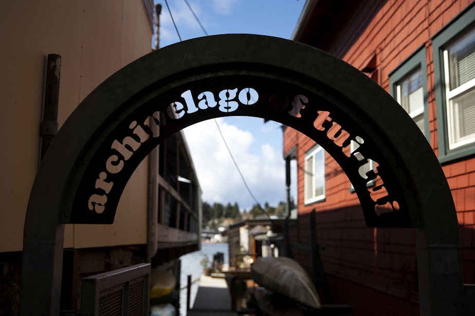 caption: An arched sign reads ‘archipelago of tui-tui’ leading to the self declared sovereign nation of Tui Tui, Janet Yoder and Robert Rudine’s houseboat, on Tuesday, March 26, 2024, in Seattle.