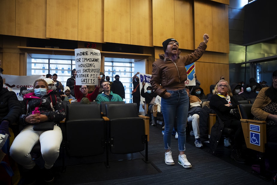 caption: Rosario Lopez leads a chant in Council chambers following public comment after asylum seekers, activists and allies marched to Seattle City Hall to ask for assistance with housing on Tuesday, February 27, 2024, in Seattle. Seattle City Council members abruptly left Council chambers.