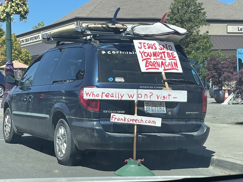 caption: One of the signs on a van parked in the middle of Sequim asks "who really won?" over six months after the last presidential election.