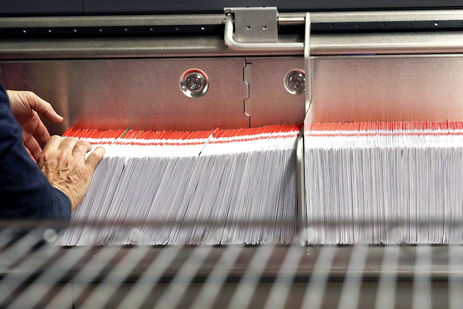 caption: FILE - This Nov. 7, 2018, file photo shows an election worker stacking ballots into a sorting machine at the King County Elections office in Renton, Wash.