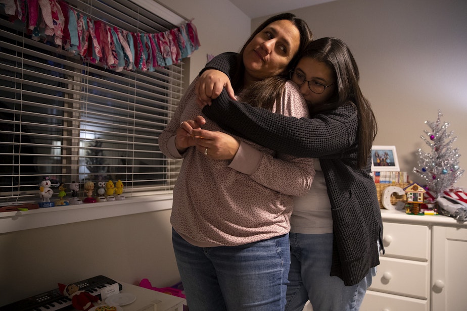 caption: Kaitlyn Mrsny, 13, hugs her mom, Christy Maricle, while sharing memories of her father, Kurt, at their home on Thursday, December 9, 2022, in Puyallup.