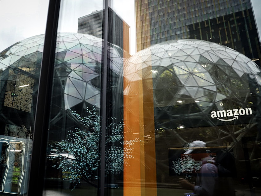caption: Amazon's iconic Spheres are shown in the reflection of a window near the company's corporate headquarters in Downtown Seattle.