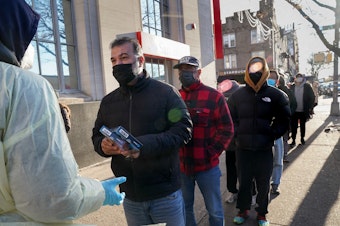 caption: Rapid COVID tests are distributed in Brooklyn in late December. Self-tests are in short supply in many parts of the country.
