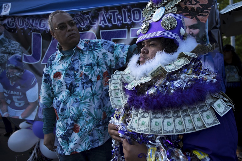 caption: Eduardo Taualo assists his son, Jabez Taualo, with a cultural headdress honoring their families heritage and High Chiefs of Samoa, ahead of taking family portraits after the Garfield High School in-person commencement ceremony for the class of 2021, on Tuesday, June 15, 2021, at Memorial Stadium in Seattle. "It's a true honor to be here today," said Taualo.