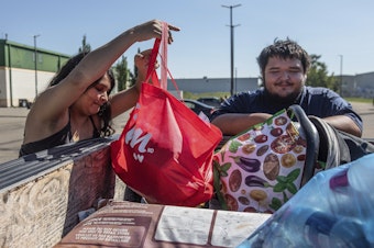 caption: Hay River, N.W.T. fire evacuees Tanisha Edison and her boyfriend Mason Bruneau go through their belongings at the evacuee center in St. Albert, Alberta, on Wednesday, Aug. 16, 2023.
