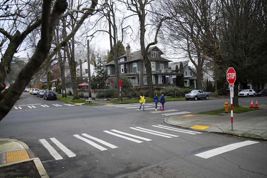 caption: Betty Gray, 80, also known as "Miss Betty," helps students across the street after school on Tuesday, Jan. 14, 2025, outside of Stevens Elementary School in Seattle.