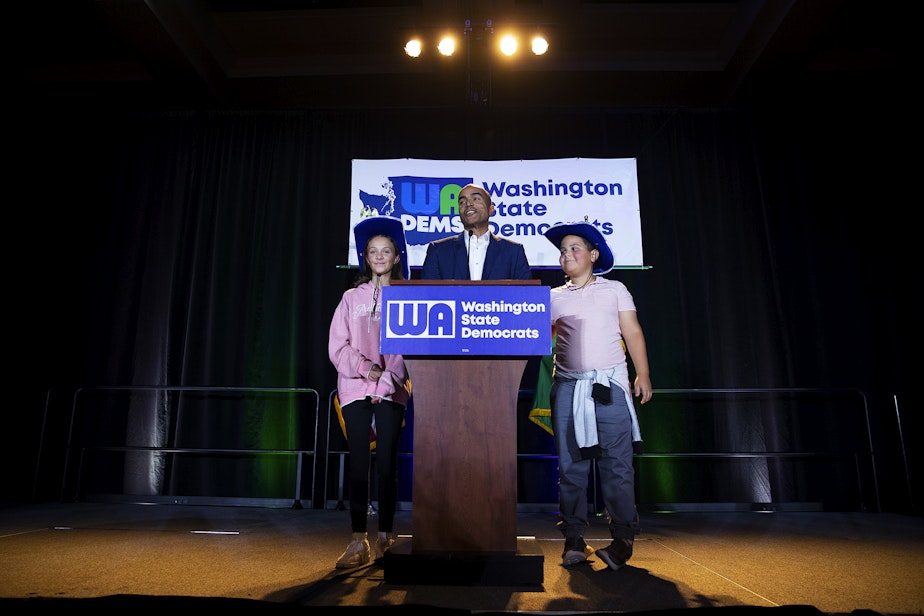 caption: Former U.S. Attorney Nick Brown, candidate for Attorney General, speaks to a crowd with his two children, on Tuesday, November 5, 2024, during the Washington Democrats election night party at the Seattle Convention Center in Seattle.