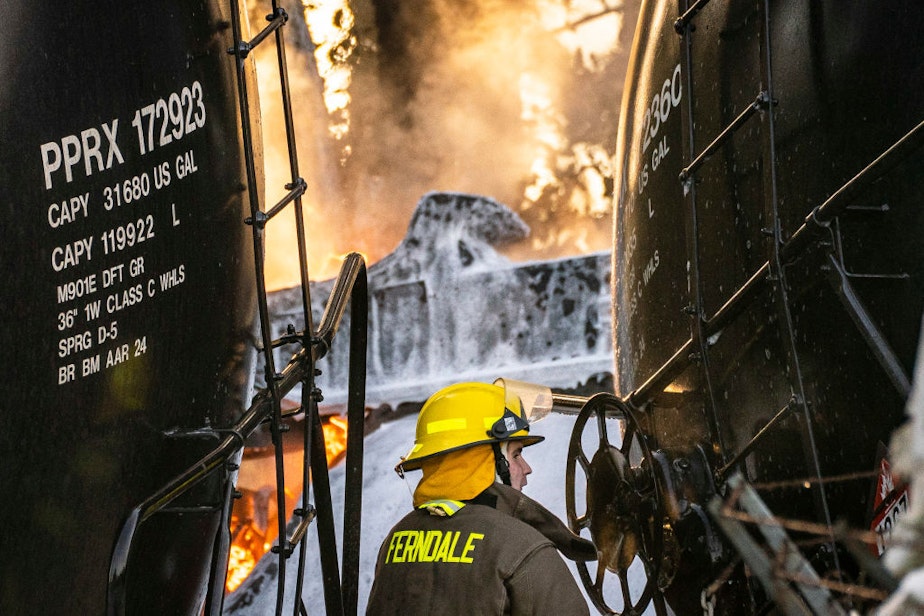 caption: A firefighter works as a derailed train carrying crude oil burns on Dec. 22 in Custer, Washington.
